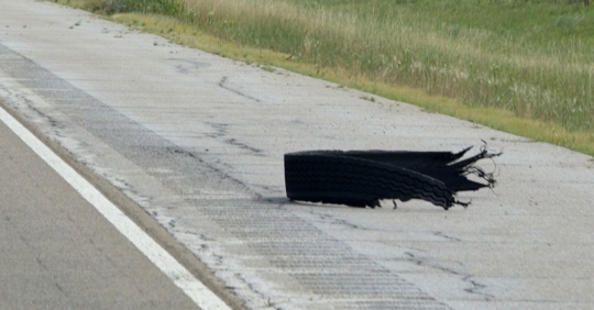 Photo of a tire shred, or "road gator", on the side of the highway.