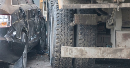 Photo of the back wheels of a truck and car, which look to have collided.